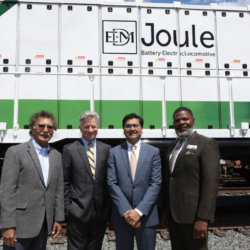 Cordero, GIlbertson, Bose, and Cliatt stand in front of a zero emissions train